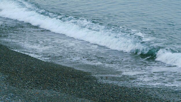 Golven lopen over de kust kiezels oceaan golven op het strand strand met kiezels die draagt de golven naar de