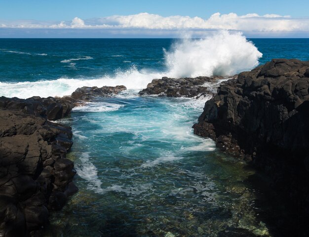 Golven raken rotsen bij Queens Bath Kauai