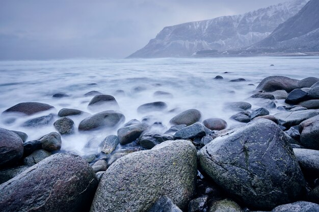 Golven van de Noorse zee stijgende op stenen rotsen. Lange blootstelling