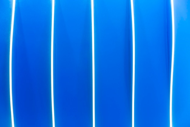 Golvende witte strepen op een heldere blauwe achtergrond Abstracte achtergrond en moderne trends in decoratie en interieur Ruimte voor tekst