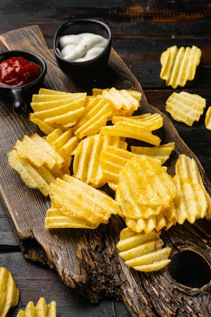 Golvende Zout Peper Gearomatiseerde Aardappelchips op oude donkere houten tafel achtergrond