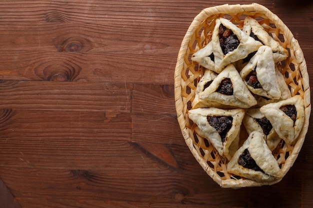 Gomentash con semi di papavero e prugne appena sfornate per la festa di purim su un tavolo di legno i