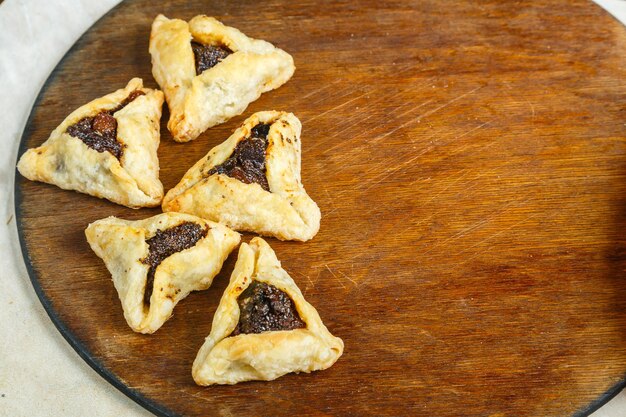 Gomentashi cookies for Purim holiday on a table on a wooden board save a place