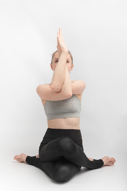 Foto gomukhasana. posa del fronte della mucca. la bella giovane donna pratica le asana di yoga. la ragazza snella di sport fa hatha yoga.