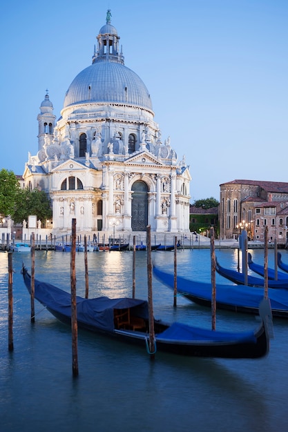 Foto gondole sul canal grande con la basilica di santa maria della salute in background, venezia, italia