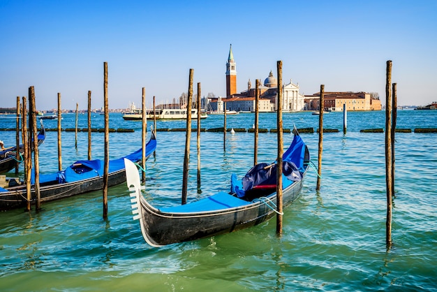 Gondolas moored by Saint Mark square with San Giorgio di Maggiore church in the background - Venice, Venezia, Italy, Europe