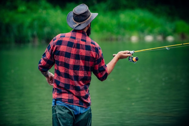 釣りに行った釣り淡水湖の池の川趣味とスポーツ活動成功したフライフィッシング週末の時間男ひげを生やした漁師インスピレーションを得て作る楽しい時間を過ごす