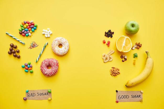 Good and bad sugars concept two handfuls of unhealthy candies and fresh and dried fruits