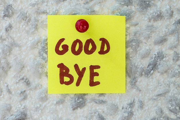 GOOD BYE text written on sticky note on gray