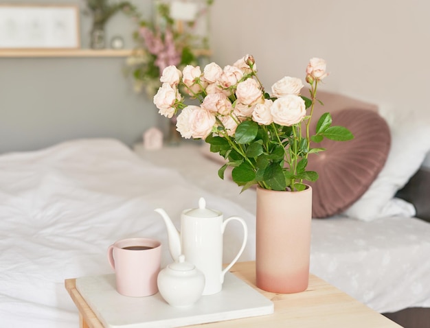 Good cozy morning Bouquet of rose flowers in vase on table Hotel room with bed Check in hotel Rest and relaxation Coffee in bed Romantic breakfast Valentine's Day