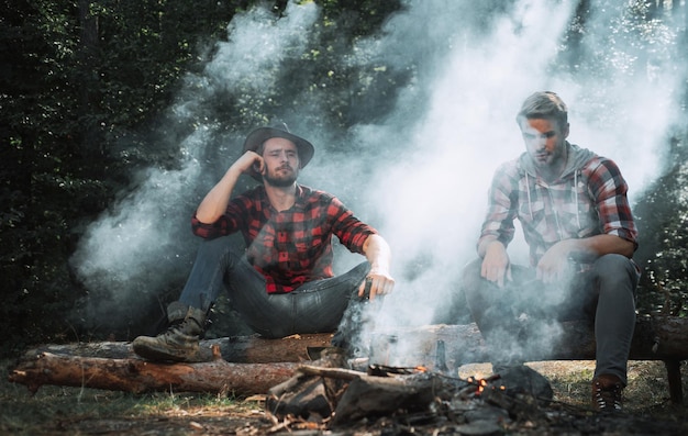 Good day for spring picnic in nature happy friends enjoying bonfire in nature friends having fun at