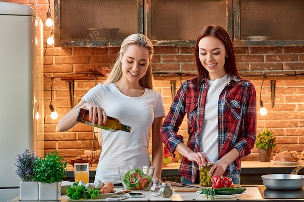 良い友達と共有すると、おいしい料理はすべて甘くなります若い女性の友達が準備しています