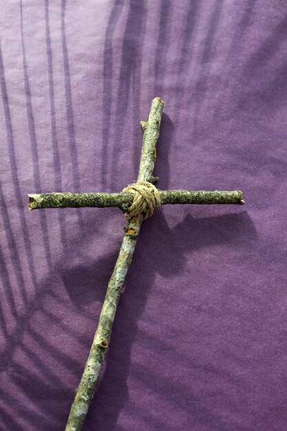 Photo good friday lent season and holy week concept a christian cross and shadow of palm leaf on purple background copy space