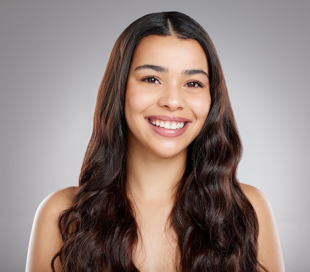 A good hair stylist is a sheer delight Studio portrait of an attractive young woman posing against a grey background