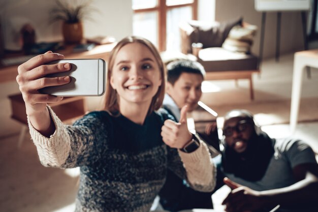 良い仕事多民族の男はオフィスでSelfieを取ります。