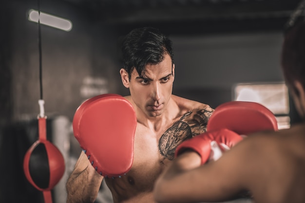 Good kick. Two kickboxers working on kicks in a gym