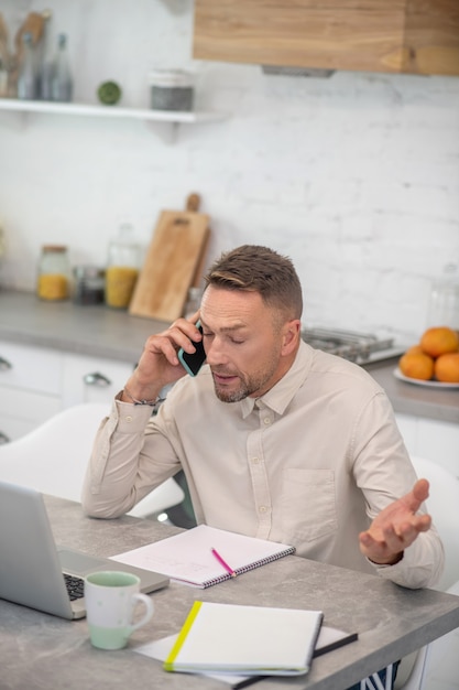 Good-looking bearded man sitting in the kitchen and talking