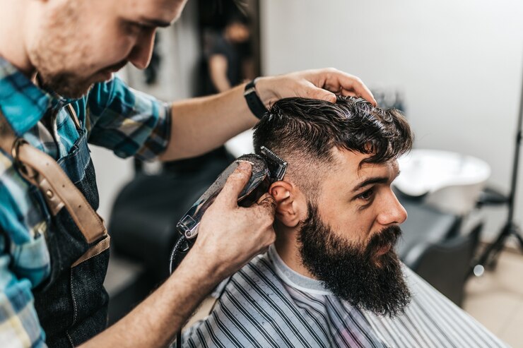 Photo good looking bearded man visiting hairstylist in barber shop.