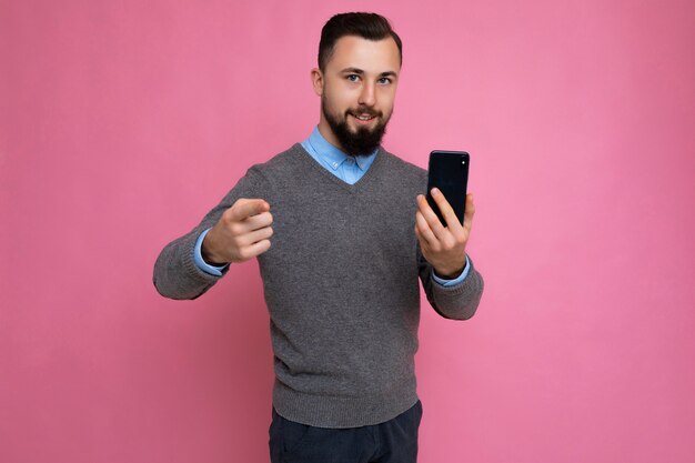 格好良い幸せなクールな若いブルネットの無精ひげを生やした男