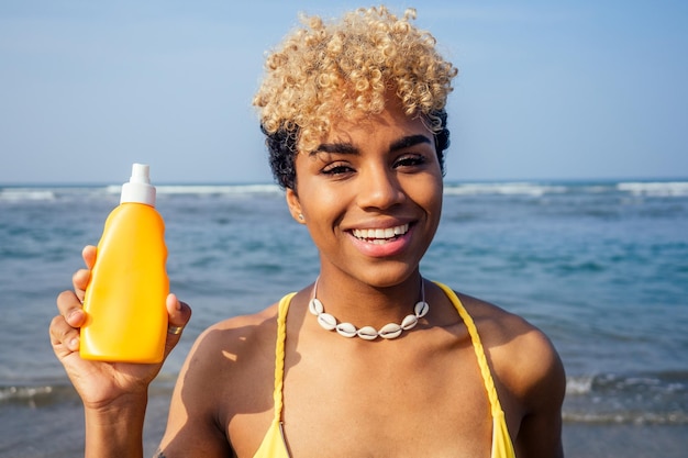 Good looking hispanic brazilian woman holding sunscreen bottle