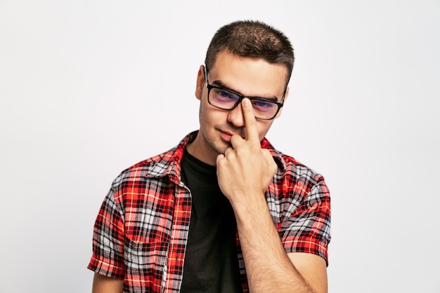 Good looking man in red and white shirt looking over stylish eyeglasses