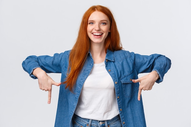 Good-looking redhead female in denim and white shirt