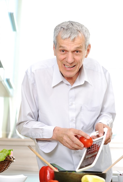 Good looking senior  man working in kitchen