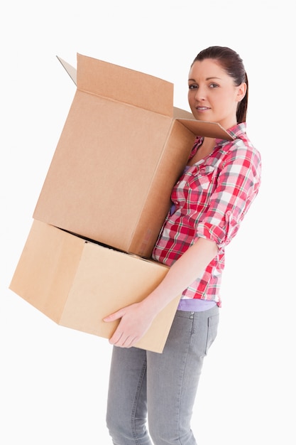 Good looking woman holding cardboard boxes while standing