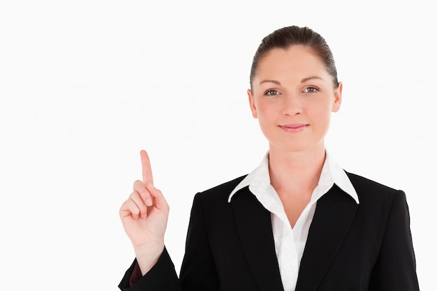 Good looking woman in suit pointing at a copy space