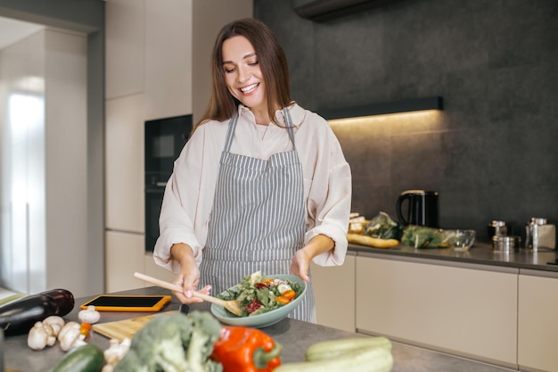 Good mood. Cute positive woman in the kitchen