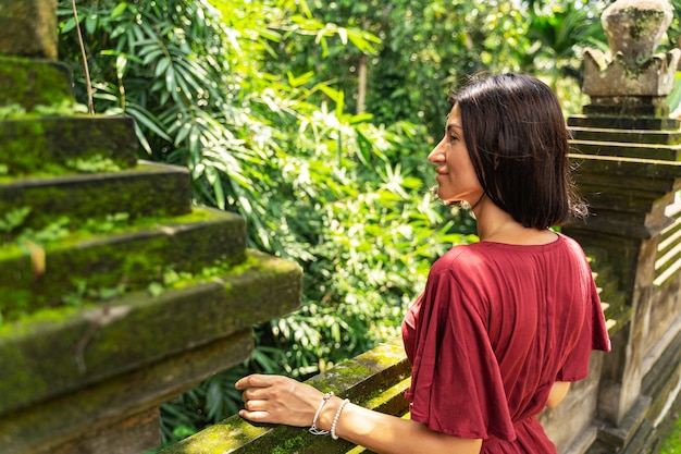 Good mood. Relaxed brunette girl keeping smile on her face while standing in semi position