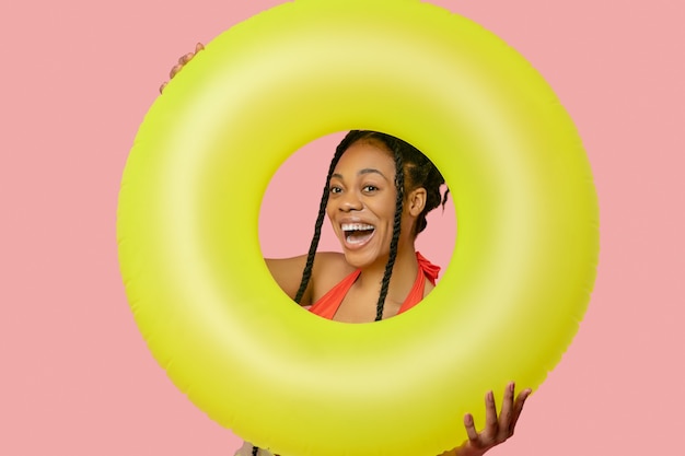 Good mood. Smiling african american woman holding a yellow tube and having fun