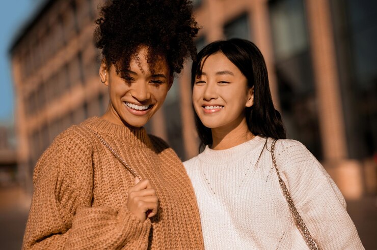 Good mood. Two pretty girls walking and talking, feeling joyful