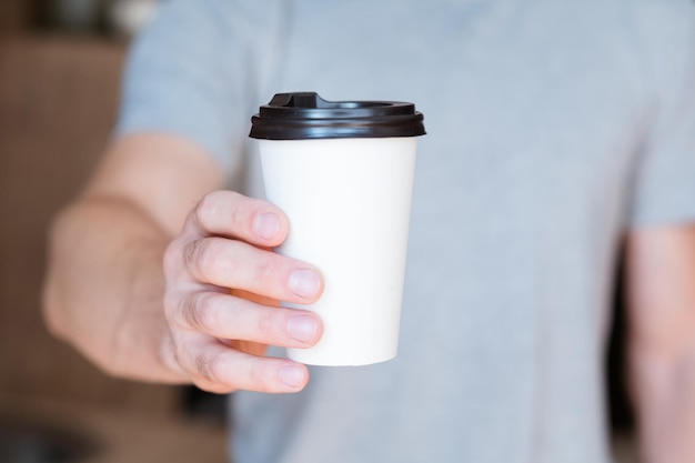 おはよう目覚めエネルギーと活力の飲み物紙のコーヒーカップを提供する男クロップドショット