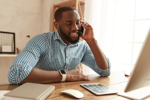 Good news happy afro american businessman in shirt talking by phone with client and smiling