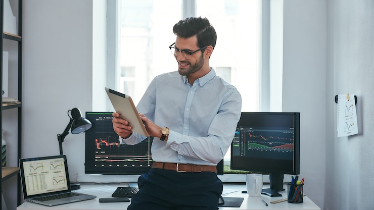Photo good news happy young trader in formal wear is looking is using his digital tablet
