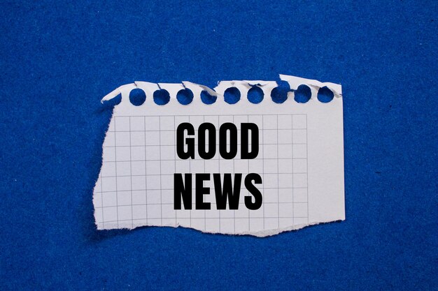 good news message written on ripped torn paper piece with blue background conceptual good news symbol copy space