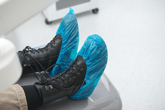 A good patient have worn a pair of blue disposable shoes over hers while the visit to the doctor