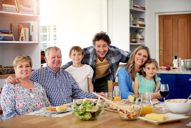 Хорошие времена всегда в меню на семейных собраниях Портрет семьи из нескольких поколений, наслаждающейся едой вместе дома
