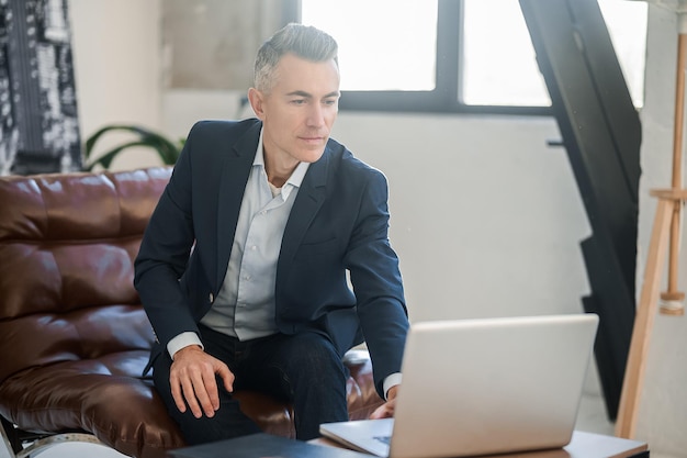 Goodlooking elegant man in a suit in the office