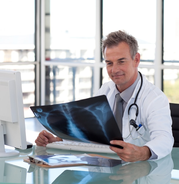 Goodlooking male doctor examining a x-ray