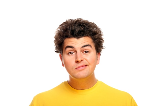 A goofy face of a young man standing against white background