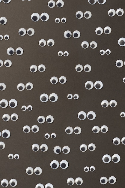 Photo googly plastic eyes pattern used to imitate eyeballs for toys and dolls and others creativity on a black backgroud. top view.