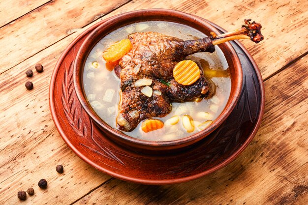 Goose vegetable soup with noodles on wooden table