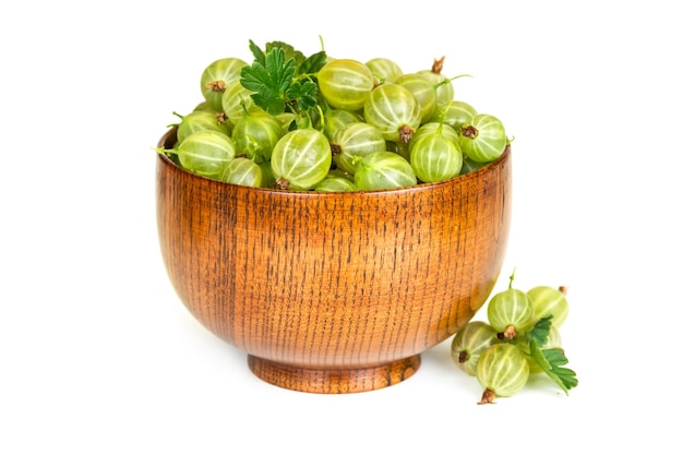 Gooseberries in a wooden bowl isolated on white background