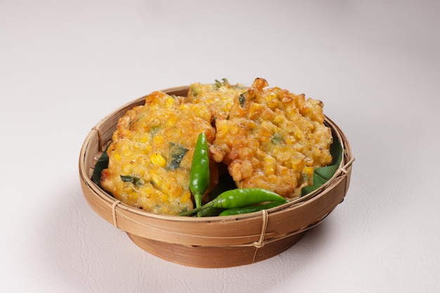 Gorengan Bakwan Jagung or Perkedel Jagung Corn Fritters with Green Chili Served on a Wooden Plate