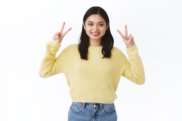 Gorgeous asian woman showing kawaii peace gesture and smiling express positivity and cuteness feeling happy promotion of korean or asia makeup products advertisement concept