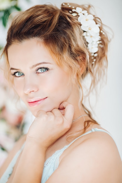 Gorgeous and beautiful woman with curly hairstyle with flowers.