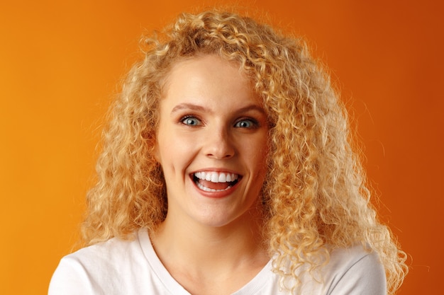 Gorgeous beautiful young woman with curly hair posing at camera