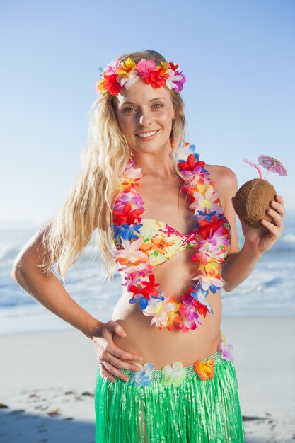 Великолепная блондинка в гирлянде с коктейлем на пляже